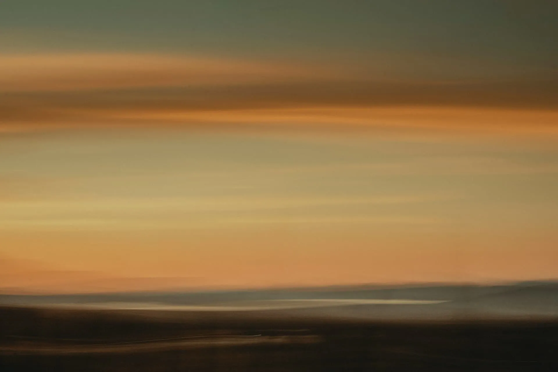 Soft horizontal bands of amber and tan light at dusk