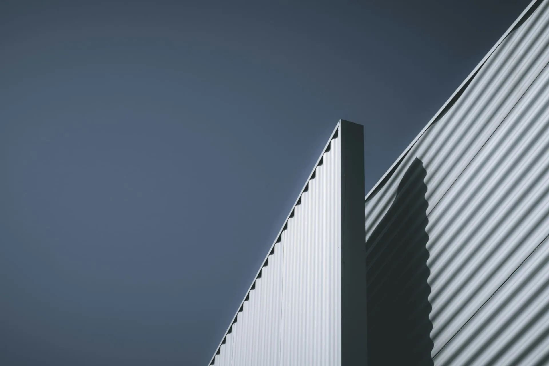 Corrugated steel façade against a deep blue sky